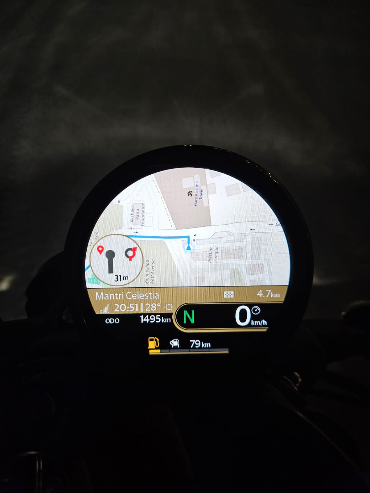 The app's map and a turn callout rendered on a motorcycle instrument cluster